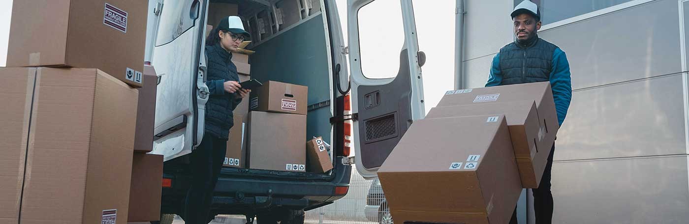 photo of two delivery workers unloading boxes from a van