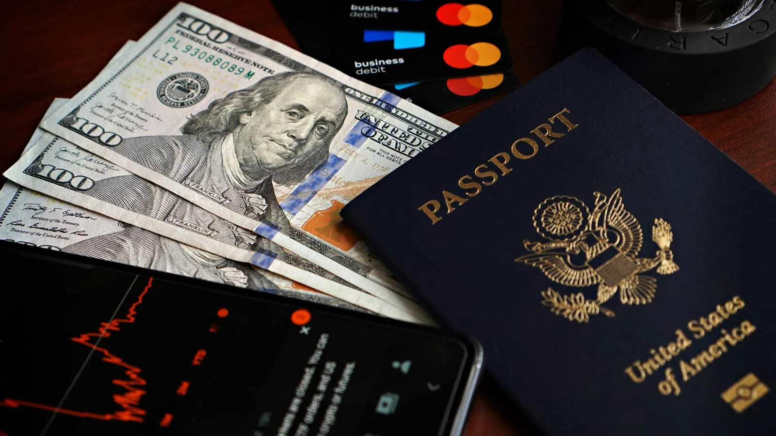 Image of cash with a passport (Photo by  Dave Garcia/Pexels)