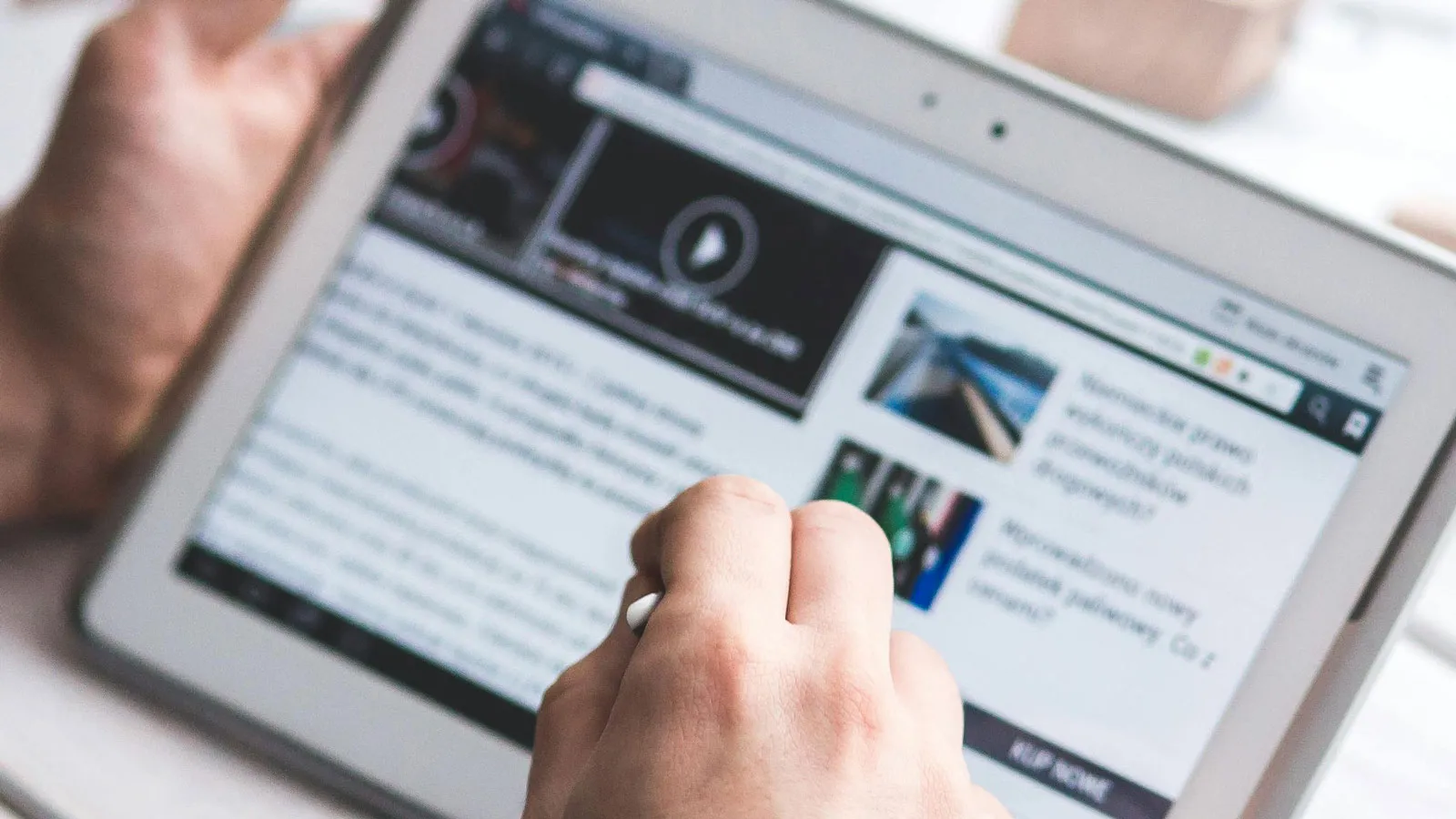 Photo of man reading news on a tablet (Photo by Kapoompics/Pexels)