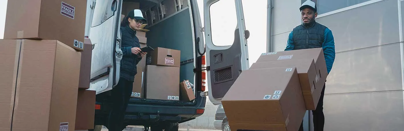 photo of two delivery workers unloading boxes from a van